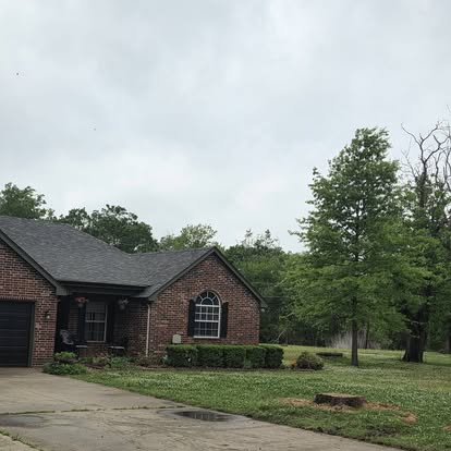 Brick home with healthy mature trees after trimming